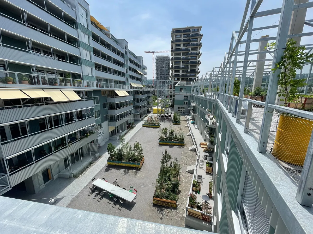 Blick auf den Innenhof der Siedlung Westhof.  Bild von einem Innenhof von oben, im Hintergrund hat es einen grossen Wohnblock.